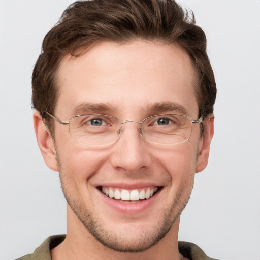 Joyful white young-adult male with short  brown hair and grey eyes