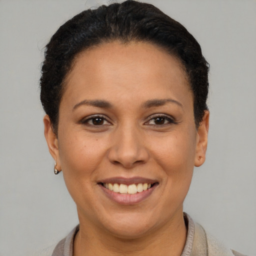 Joyful latino adult female with short  brown hair and brown eyes