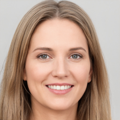 Joyful white young-adult female with long  brown hair and grey eyes