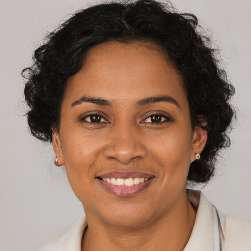 Joyful black adult female with long  brown hair and brown eyes