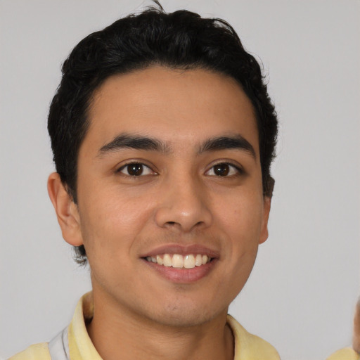 Joyful latino young-adult male with short  brown hair and brown eyes