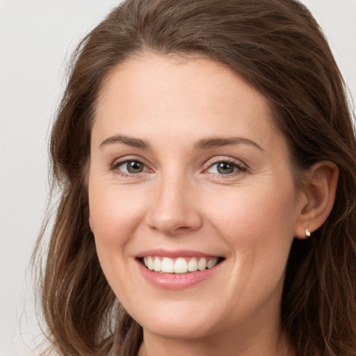 Joyful white young-adult female with long  brown hair and grey eyes