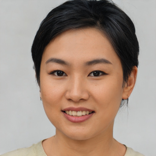 Joyful asian young-adult female with short  black hair and brown eyes