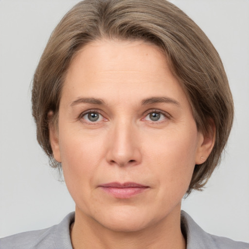 Joyful white adult female with medium  brown hair and grey eyes