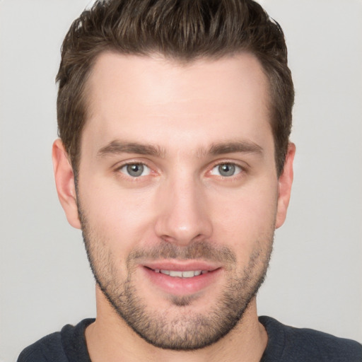 Joyful white young-adult male with short  brown hair and brown eyes