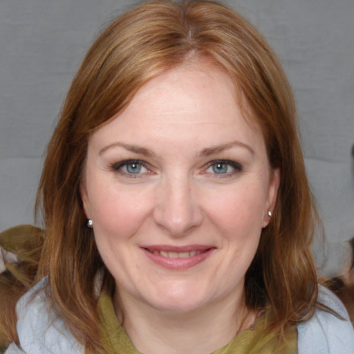 Joyful white adult female with medium  brown hair and blue eyes