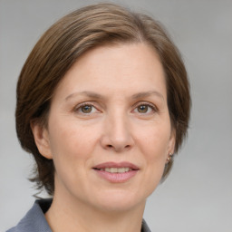 Joyful white adult female with medium  brown hair and grey eyes