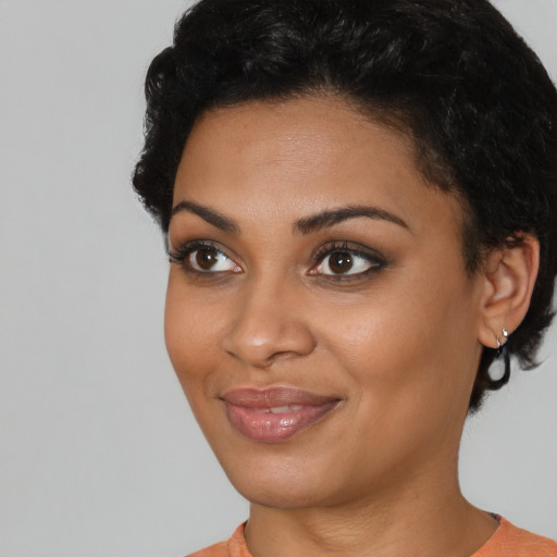 Joyful black young-adult female with short  black hair and brown eyes