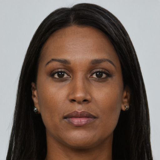 Joyful black young-adult female with long  brown hair and brown eyes