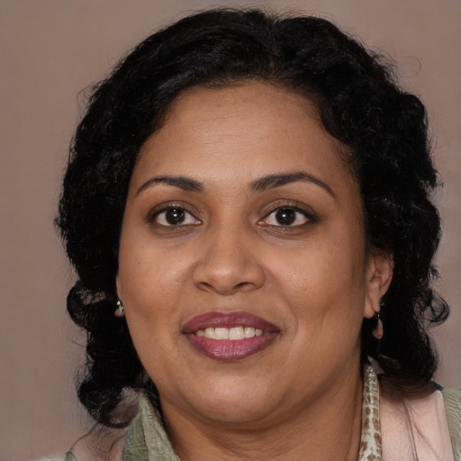 Joyful latino adult female with medium  brown hair and brown eyes