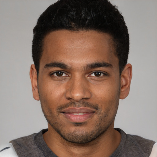 Joyful black young-adult male with short  brown hair and brown eyes