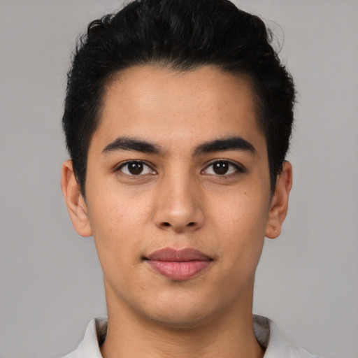 Joyful latino young-adult male with short  black hair and brown eyes