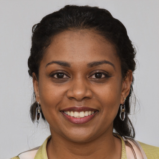 Joyful black young-adult female with short  brown hair and brown eyes