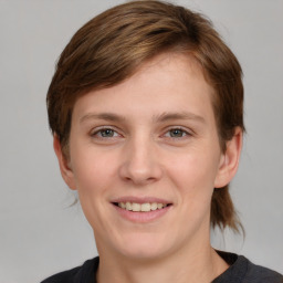 Joyful white young-adult female with medium  brown hair and grey eyes