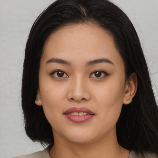 Joyful asian young-adult female with long  brown hair and brown eyes