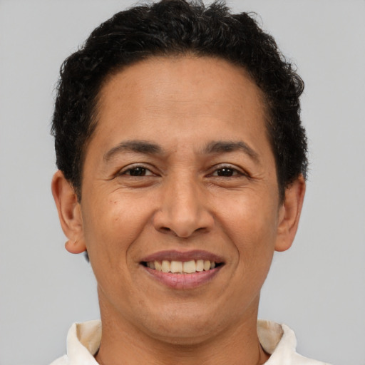 Joyful latino adult male with short  brown hair and brown eyes