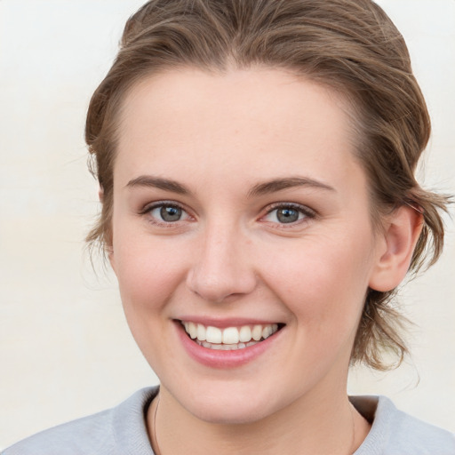 Joyful white young-adult female with medium  brown hair and blue eyes