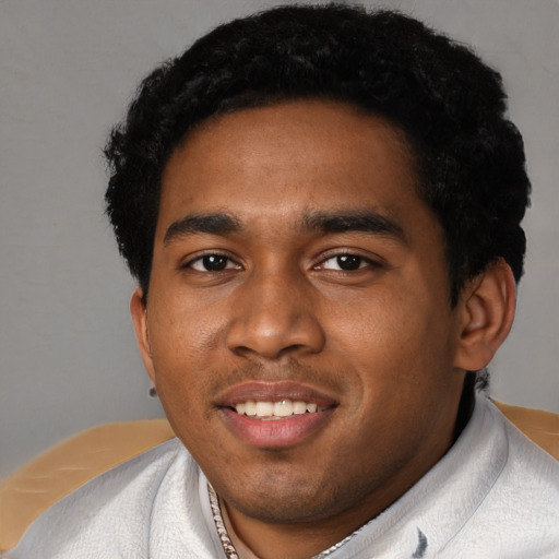 Joyful black young-adult male with short  black hair and brown eyes