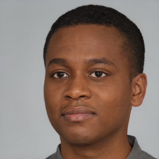 Joyful black young-adult male with short  brown hair and brown eyes