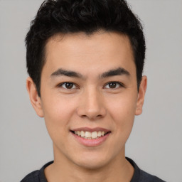 Joyful latino young-adult male with short  brown hair and brown eyes