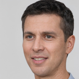 Joyful white adult male with short  brown hair and brown eyes