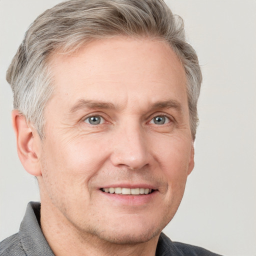 Joyful white adult male with short  brown hair and grey eyes