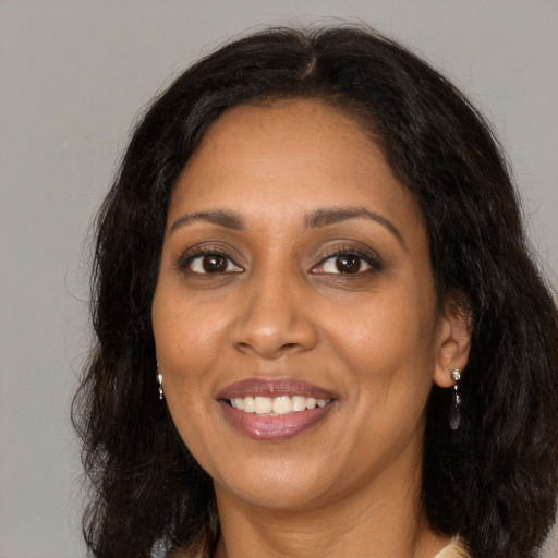 Joyful black adult female with long  brown hair and brown eyes