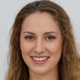 Joyful white young-adult female with long  brown hair and green eyes