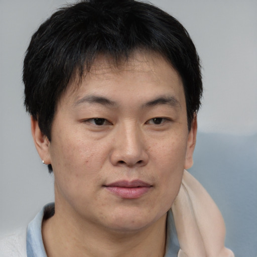 Joyful asian young-adult male with short  brown hair and brown eyes