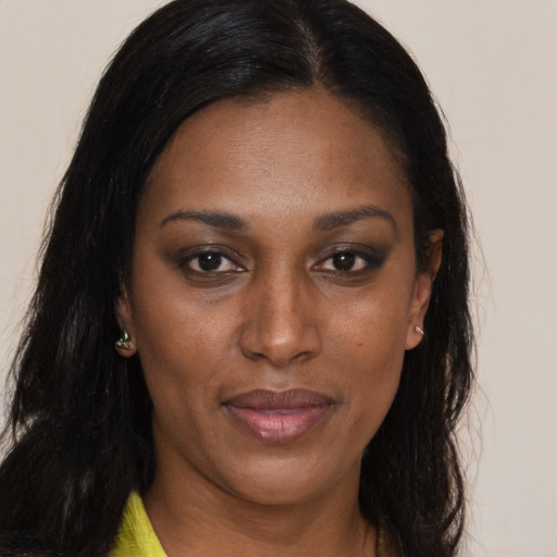 Joyful black adult female with long  brown hair and brown eyes
