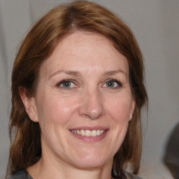 Joyful white adult female with medium  brown hair and grey eyes