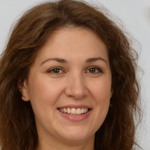 Joyful white adult female with long  brown hair and brown eyes