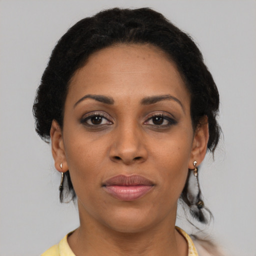 Joyful black adult female with short  brown hair and brown eyes