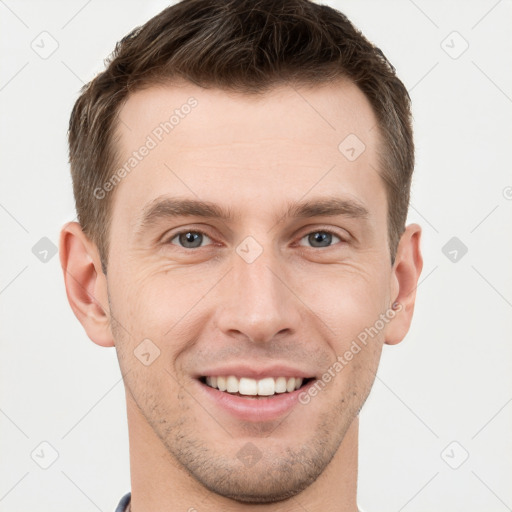 Joyful white young-adult male with short  brown hair and grey eyes