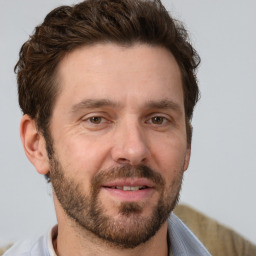 Joyful white adult male with short  brown hair and brown eyes