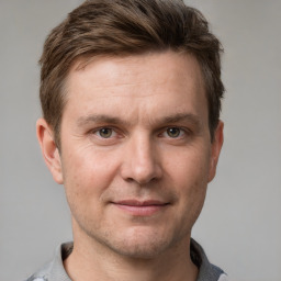 Joyful white adult male with short  brown hair and grey eyes