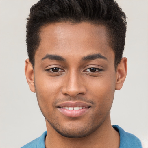 Joyful black young-adult male with short  brown hair and brown eyes