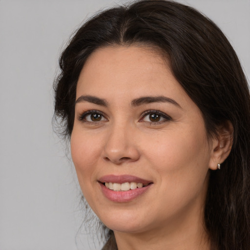 Joyful white adult female with long  brown hair and brown eyes