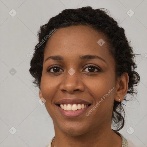 Joyful black young-adult female with long  brown hair and brown eyes