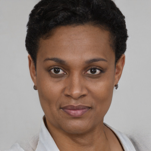 Joyful black young-adult female with short  black hair and brown eyes