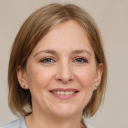 Joyful white adult female with medium  brown hair and grey eyes