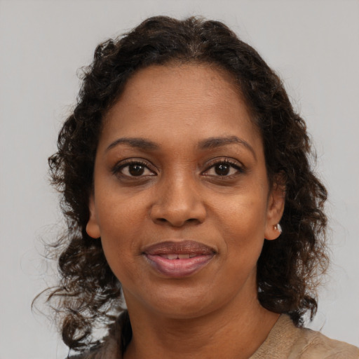 Joyful black adult female with medium  brown hair and brown eyes