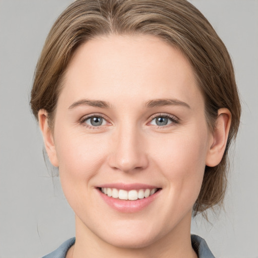 Joyful white young-adult female with medium  brown hair and grey eyes