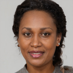 Joyful black adult female with medium  brown hair and brown eyes