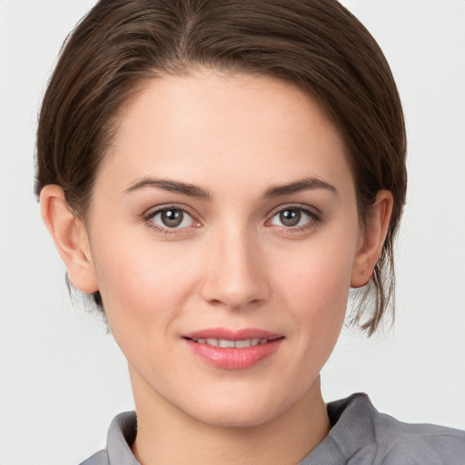 Joyful white young-adult female with medium  brown hair and grey eyes