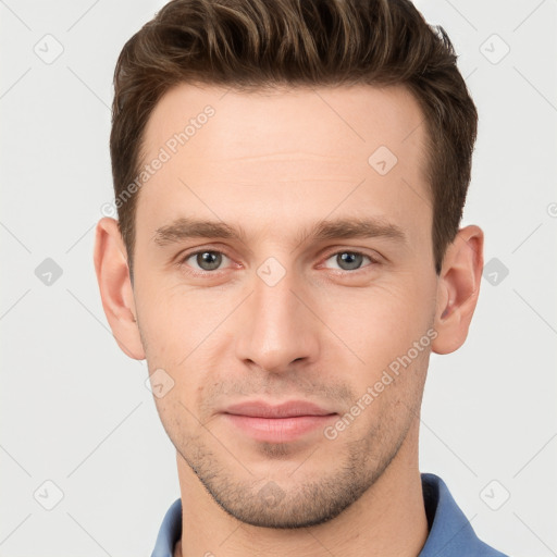 Joyful white young-adult male with short  brown hair and grey eyes