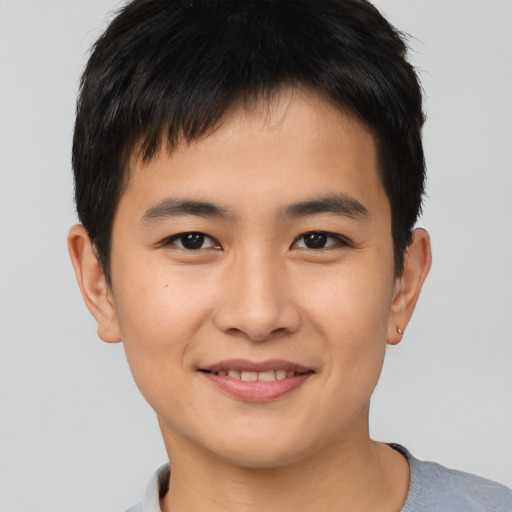 Joyful asian young-adult male with short  brown hair and brown eyes