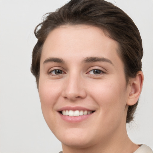 Joyful white young-adult female with short  brown hair and grey eyes