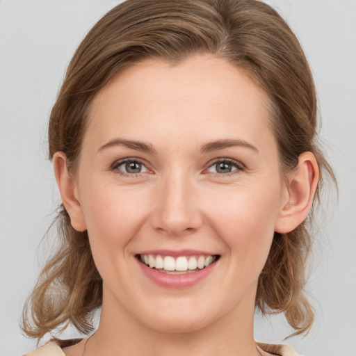 Joyful white young-adult female with medium  brown hair and grey eyes