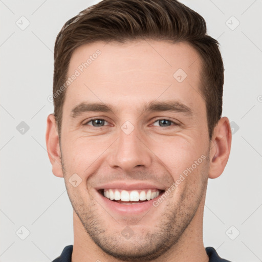 Joyful white young-adult male with short  brown hair and grey eyes